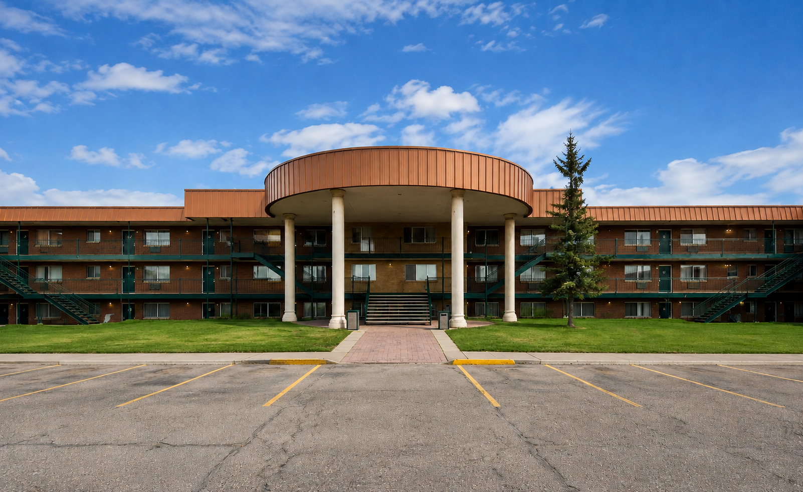 Sunset Suites brick building exterior with columned portico
